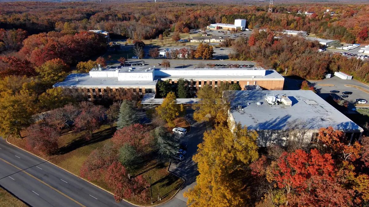 Elevated aerial perspective of flat commercial rooftops with rooftop equipment beside a divided road